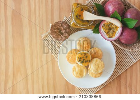 Homemade delicious scones with homemade passion fruit jam in top view flat lay with copy space for background or wallpaper. Scones is traditional English pastry for serve with afternoon tea or coffee. Scones and passion fruit jam on table.