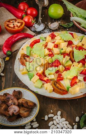 Tortilla with salad over it, surrounded by ingredients