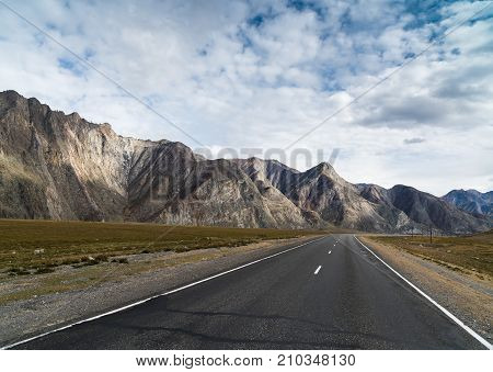 Federal highway M-52 Chuysky tract, asphalted road with markings leaving for the mountains beyond the horizon