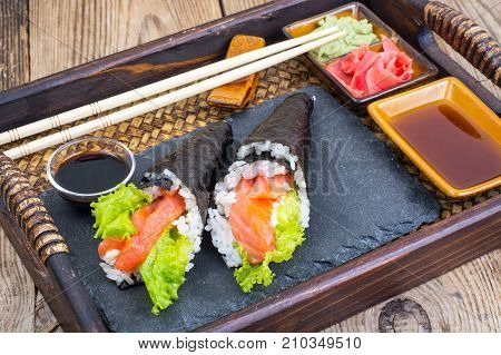 Salmon temaki sushi cone on the tray. Studio Photo