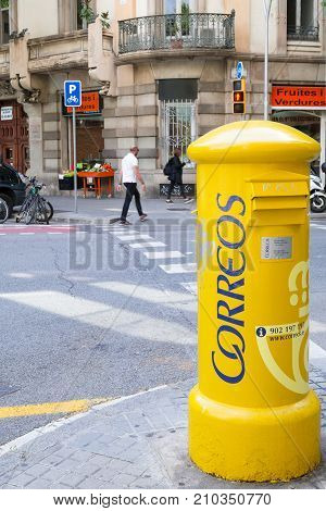 Big yellow mailbox at the crossways in the capital of Catalonia. Barcelona, Spain - May 5 2016.