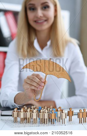 Smiling Business woman in hand holds a miniature umbrella in the hand of the topic of liability insurance