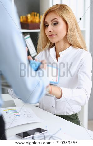 Female employee show pack of documents to busy manager or boss give extra work to executor. White collar portrait contract approval headache and depression irs lot of new problems concept