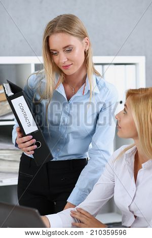 Female employee show pack of documents to busy manager or boss give extra work to executor. White collar portrait contract approval headache and depression irs lot of new problems concept