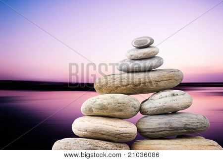 Ciottoli Stack In serata tranquilla con fondo liscio oceano. Concetto Zen.