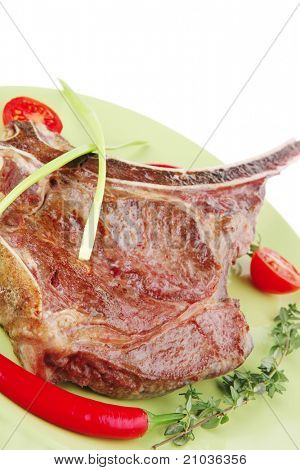 cibo di carne: manzo alla griglia di ricambio rib sul piatto verde con timo pepe e pomodoro isolato sopra ba bianco