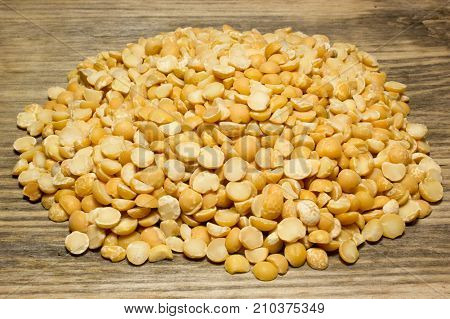 Crushed dried peas on wooden tabke as background