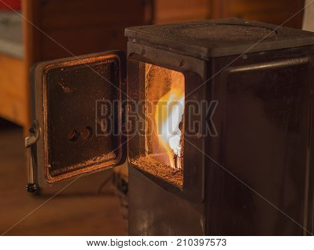 old metal open stove door with burning flame wood