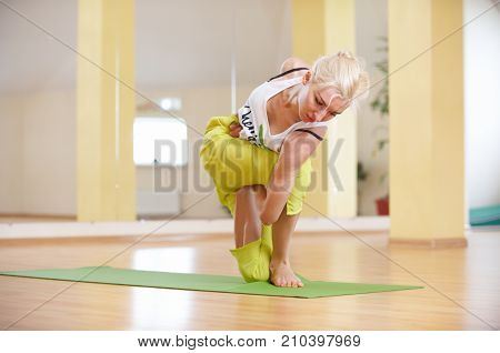 Beautiful sporty fit yogi woman practices yoga asana Parivritta Vatayanasana in the yoga class