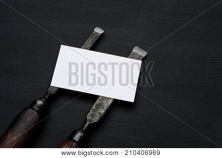 joinery tools on black wooden table background with business card and copy space.