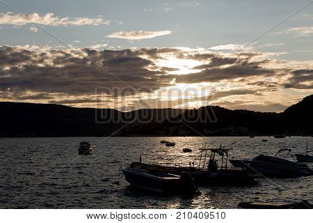 Herceg-Novi, Montenegro - September 26: boats and yachts docked at the pier in the Bay of Montenegro at sunset and mountains in the background in the European day of languages on September 26, 2017