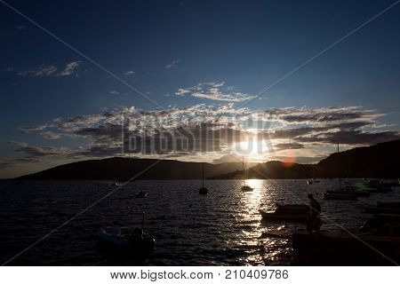 Herceg-Novi, Montenegro - September 26: boats and yachts docked at the pier in the Bay of Montenegro at sunset and mountains in the background in the European day of languages on September 26, 2017