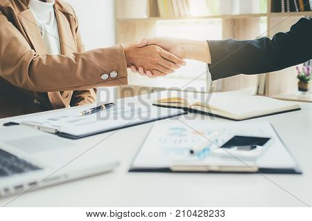 Business handshake and business people.Vintage tone Retro filter effect soft focus low light.