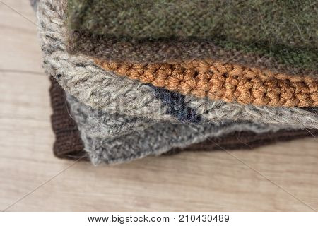 Stack of Hand Knitted Warm Winter Socks Scarfs Mittens From Coarse Wool Yarn Brown Beige Grey. Close up. Eco Fashion Kinfolk Style. Natural Materials Copy Space