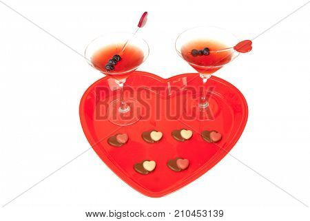 Pair of Manhattan drinks, and some heart shaped chocolates on a heart shaped tray for Valentines lovers
