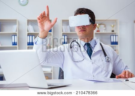 Young doctor with vr virtual reality headset working in the offi