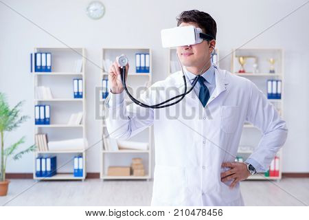 Young doctor with vr virtual reality headset working in the offi