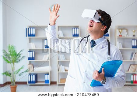 Young doctor with vr virtual reality headset working in the offi