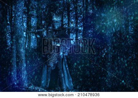 The king of the dead warriors in knightly armor stands in the night forest. Fantasy horror film. Halloween. Zombie.