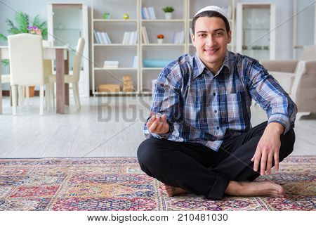 Young muslim man praying at home