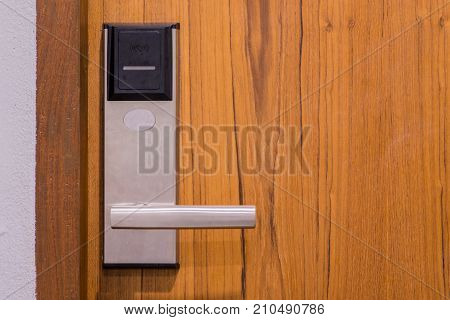 Electronic security key lock on wooden door using keycard touch the key lock to open the door to enter into the room