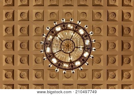 Chandelier on decoarted ceiling of a ballroom