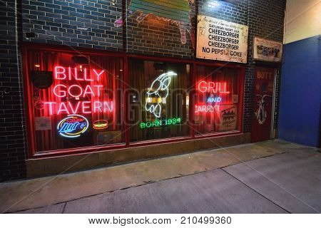 Chicago IL - July 15 2017: Famous scene downtown Chicago. The iconic Billy Goat Tavern sign welcomes into the dark Lower Wacker underpass beneath the upscale Michigan Avenue shopping district.