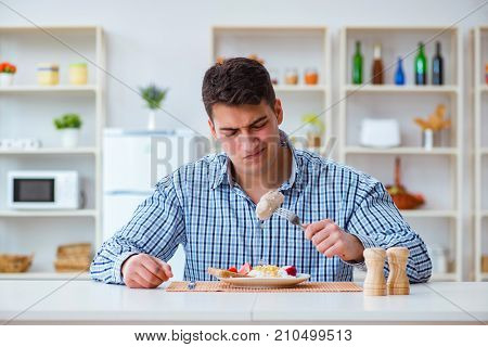 Man eating tasteless food at home for lunch