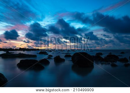 Sunset at Koh Lanta with Stones in the sea and Phi Phi islands in the horizon with long exposure, Koh Lanta, Thailand, Asia
