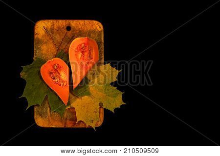 fresh cut pumpkin on a cutting board and black background