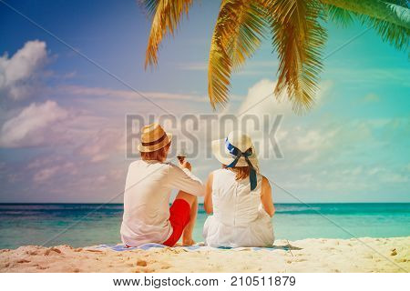 happy loving couple drinking wine at tropical beach vacation