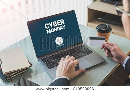 Businessman shopping online with credit card and laptop cyber Monday screen in home office or co working space.Concept of e-commerce using online technology.