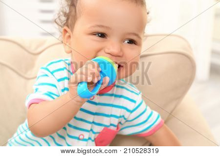 Cute little African American baby with nibbler, closeup