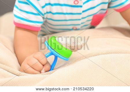Cute little African American baby with nibbler on sofa, closeup