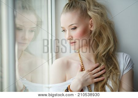 Romantic blonde. Young beautiful cute woman. Beauty girl with long shiny hair, glowing skin and voluminous haircut