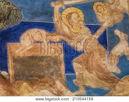 Binding of Isaac God asks Abraham to sacrifice his son Isaac but is prevented by an angel. A romanesque wall-painting in Bjaresjo church Sweden November 6 2009