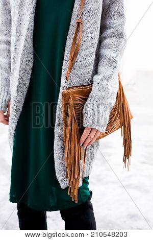 Stylish woman's outfit. Green dress, white coat, leather bag. Trendy casual outfit. Street fashion. Details of everyday look.