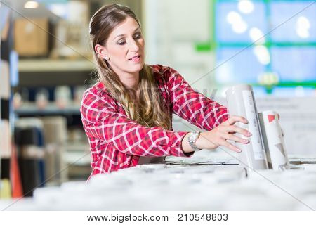 Young woman buying wallpapers in home improvement store