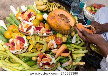 Basket full of fresh fruits and vegetables and a Caucasian man selling them on a fruit market in India