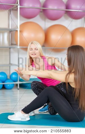 Vertical shot of a mature woman fitness trainer coaching her female client at the gym. Young woman training with her sports coach at the gym gymnastics aerobics beauty body strengthening concept