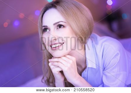 My dream. Attractive dark-eyed thoughtful woman smiling and feeling happy while dreaming of something
