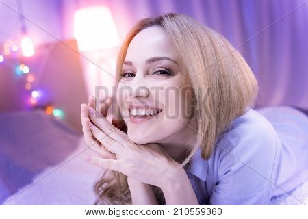 I love laughing. Pretty young blond woman lying on her stomach and laughing and her eyes shinning