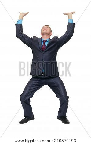 A young business man stands on bent knees and holds his hands above his head as if he is carrying something or holding it isolated on white background.