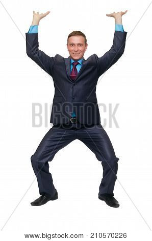A young business man stands on bent knees and holds his hands above his head as if he is carrying something or holding it isolated on white background.