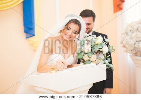 Wedding couple bride and groom leaving their signatures.