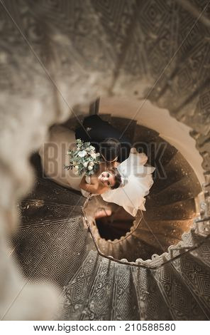 Beautiful, passionate wedding couple posing on stairs.