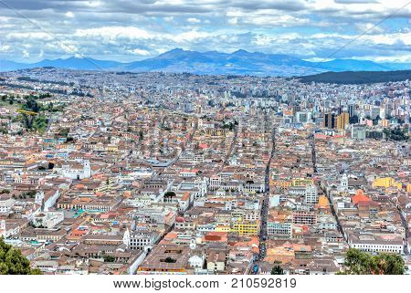 High view of Quito, from the Panecillo hill, on a cloudy and overcast afternoon. Quito, Ecuador.