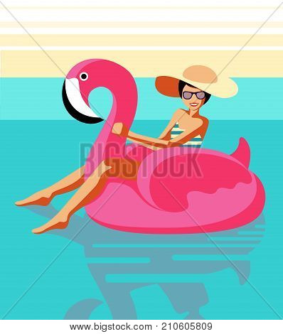 Happy smiling young girl in a swimsuit glasses and a hat sits on an inflatable pink flamingo in the pool.