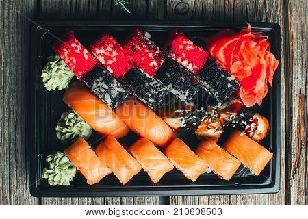 On A Wooden Table In The Black Container Are Nicely Decomposition Sushi