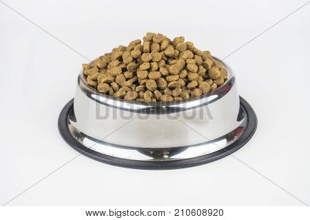 Pet food in a metal bowl on a floor.